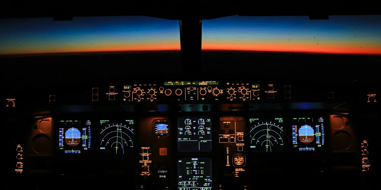 Nächtliches Airbus-Cockpit mit leuchtenden Instrumenten über dem Horizont als Sinnbild für Autopilot unter menschlicher Kontrolle
