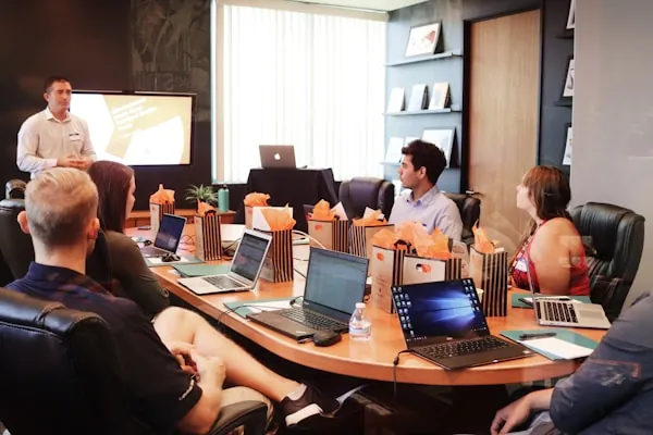Team in einer Besprechung mit Notebook und Notizen als Sinnbild für automatisierte Meeting-Protokolle