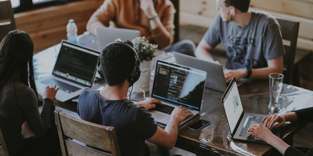 Team arbeitet gemeinsam an Laptops an einem Besprechungstisch