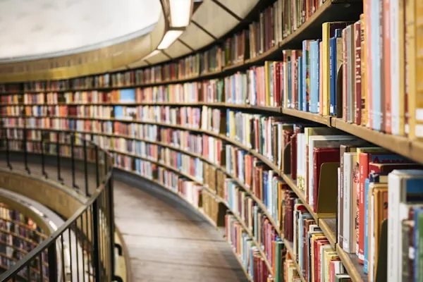 Geschwungene Bibliothek voller bunter Buchrücken als Sinnbild für durchsuchbares, KI-gestütztes Unternehmenswissen